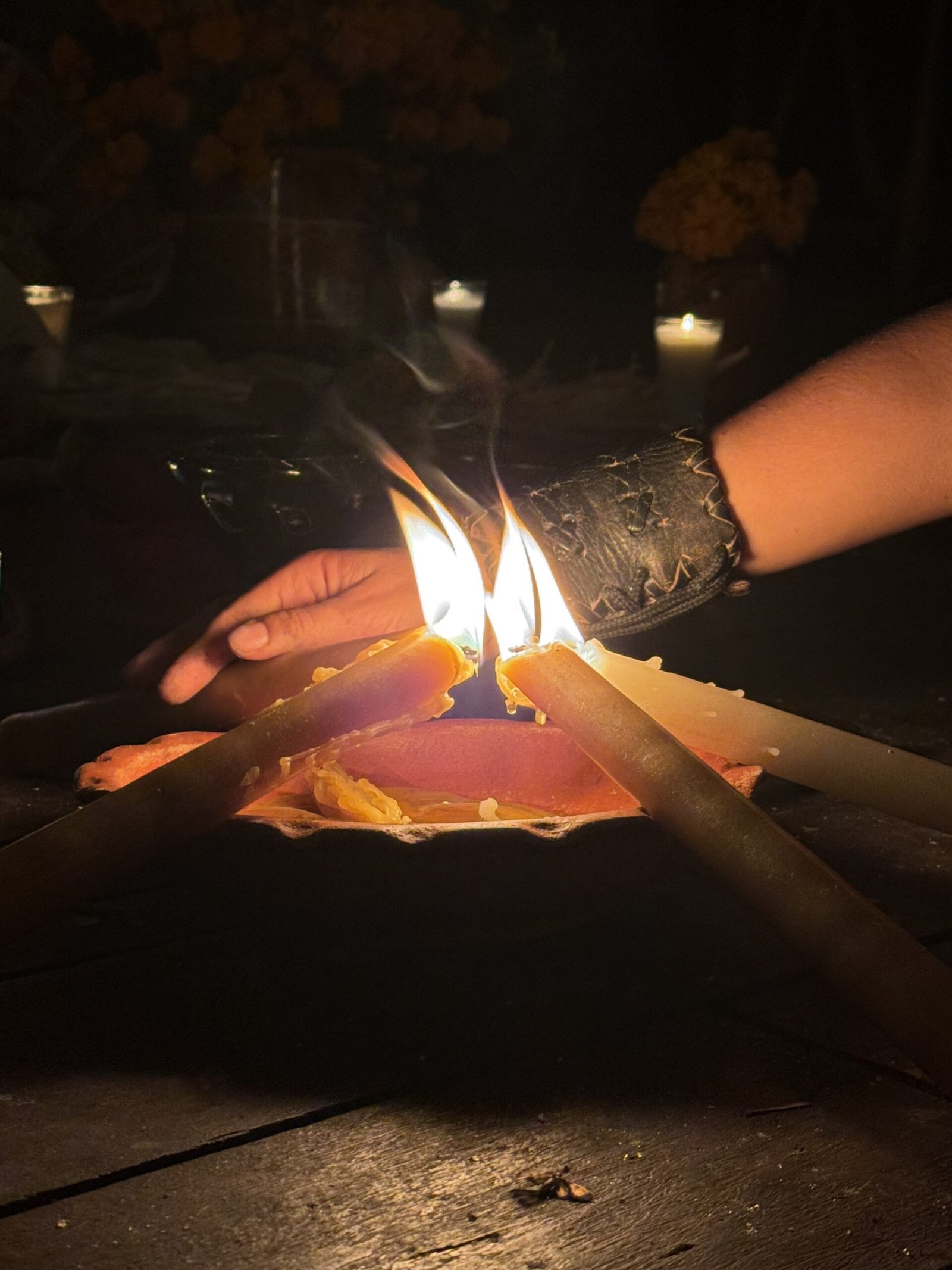 Woman lighting candle near cenote in a night remembrance ritual