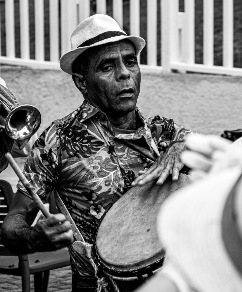 Hands of a Cuban drummer resting on the worn hide head of a batá drum